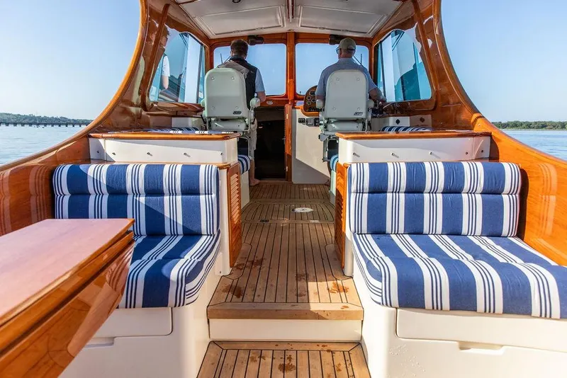 Slide: The Image of 2017 Hinckley Picnic Boat MKIII interior with striped seating and wooden finishes. - 15