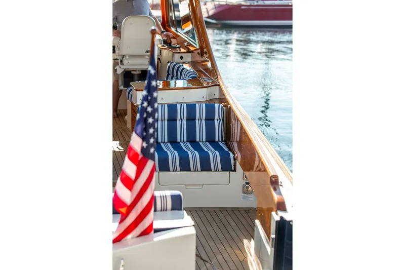 Slide: The Image of 2017 Hinckley Picnic Boat MKIII with striped seating and American flag on deck. - 17