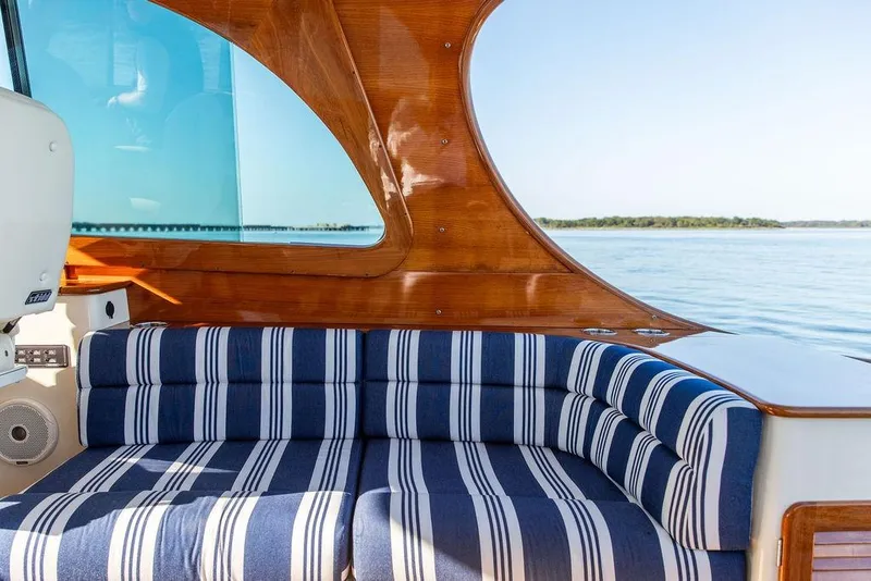 Slide: The Image of Interior of 2017 Hinckley Picnic Boat MKIII with striped seating and wooden accents. - 19