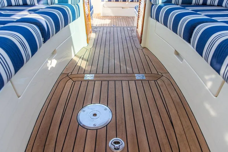 Slide: The Image of Interior of 2017 Hinckley Picnic Boat MKIII with striped seating and wooden flooring. - 23