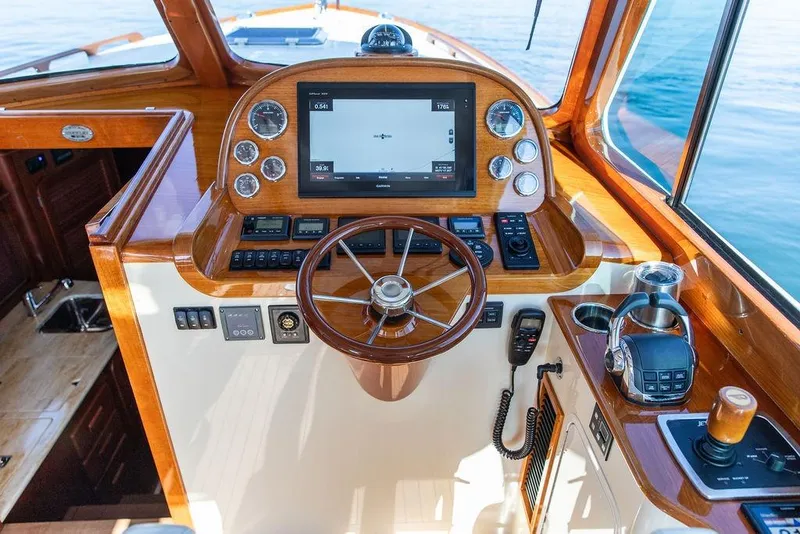 Slide: The Image of Hinckley Picnic Boat MKIII 2017 helm with wooden finish, modern controls, and navigation display. - 27