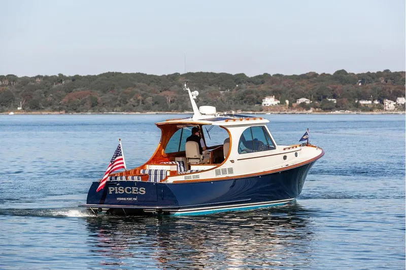 Slide: The Image of 2017 Hinckley Picnic Boat MKIII cruising on calm waters with scenic shoreline backdrop. - 3