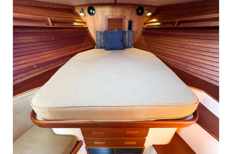 Slide: The Image of 2017 Hinckley Picnic Boat MKIII interior cabin with cozy bed and wooden paneling. - 30