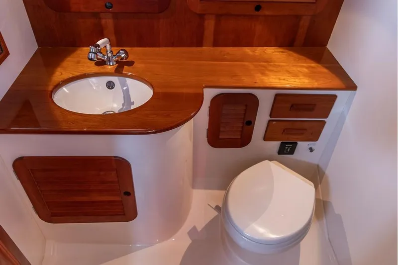 Slide: The Image of 2017 Hinckley Picnic Boat MKIII bathroom with wooden cabinetry and modern fixtures. - 31