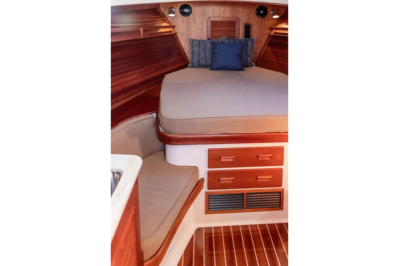 Slide: The Image of 2017 Hinckley Picnic Boat MKIII interior with wooden cabinetry and cozy sleeping area. - 35