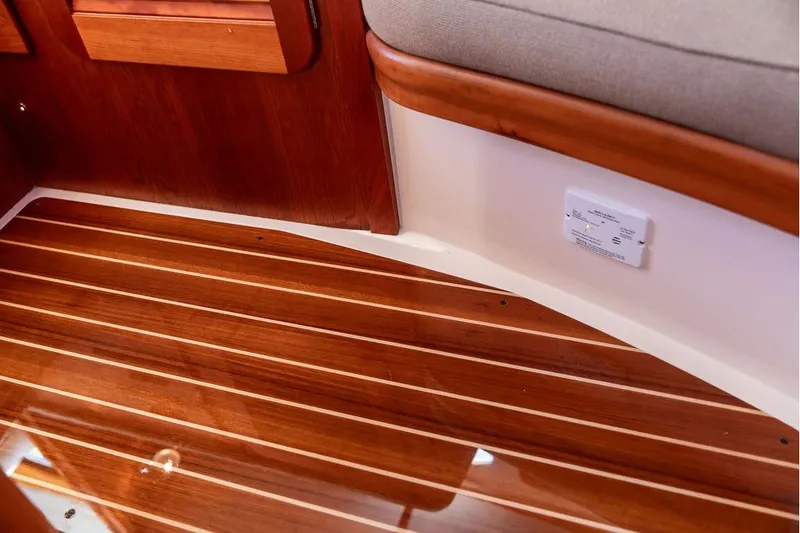 Slide: The Image of 2017 Hinckley Picnic Boat MKIII interior with polished wooden flooring and cushioned seating. - 36