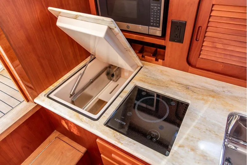 Slide: The Image of 2017 Hinckley Picnic Boat MKIII galley with stove, microwave, and storage. - 37