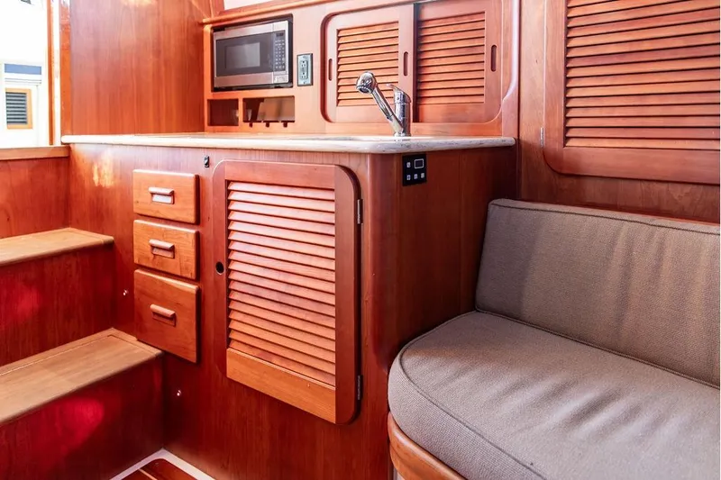 Slide: The Image of Interior of 2017 Hinckley Picnic Boat MKIII with wooden cabinetry and seating. - 38