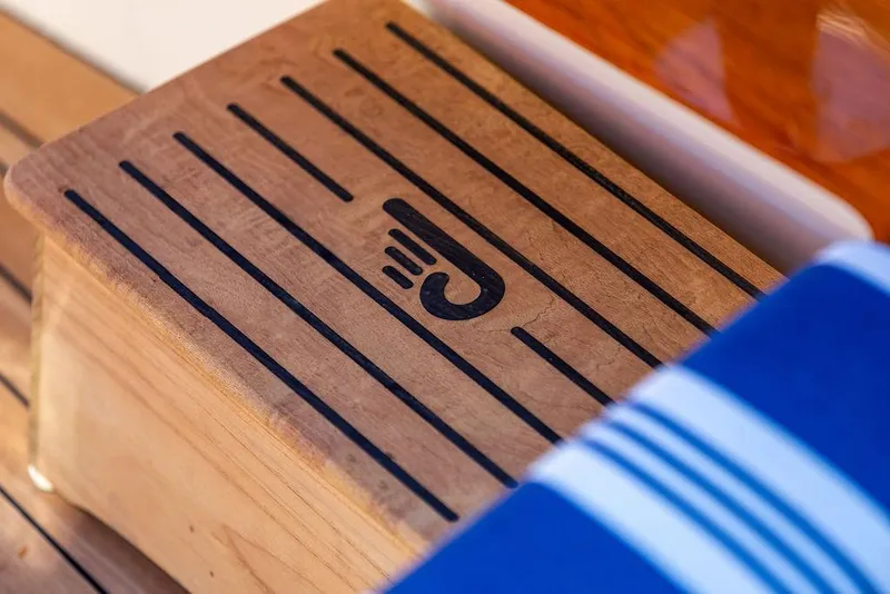 Slide: The Image of Wooden step with logo on 2017 Hinckley Picnic Boat MKIII, featuring striped fabric. - 43