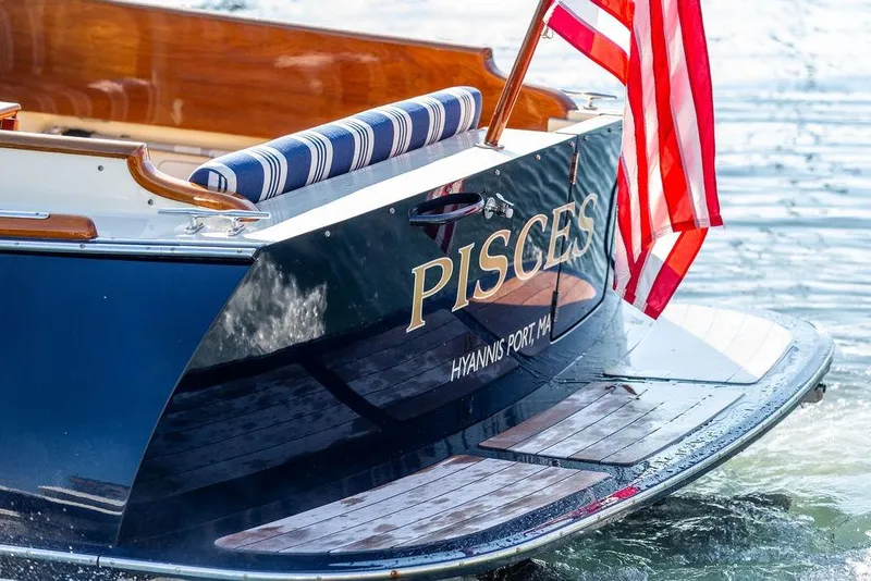 Slide: The Image of Hinckley Picnic Boat MKIII 2017 with American flag, named "Pisces," docked at Hyannis Port. - 50