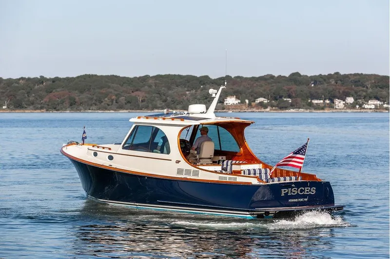 Slide: The Image of 2017 Hinckley Picnic Boat MKIII cruising on calm waters with scenic shoreline backdrop. - 6