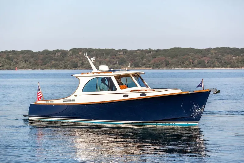Slide: The Image of 2017 Hinckley Picnic Boat MKIII cruising on calm waters with scenic background. - 8