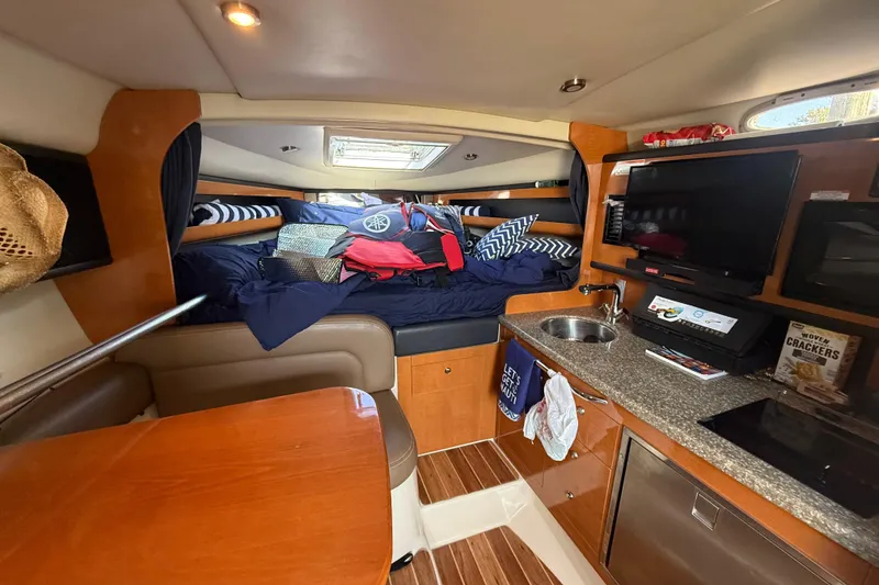 Slide: The Image of 2009 Chaparral Signature 280 cabin interior with bed, kitchenette, and TV. - 22