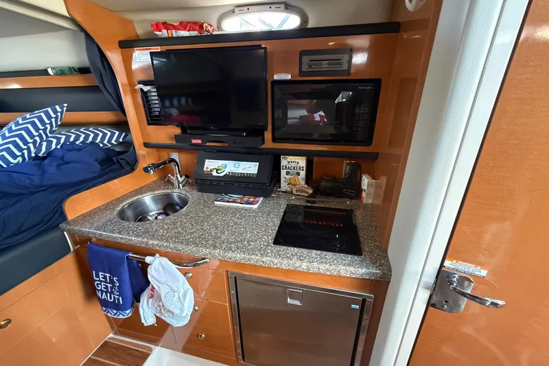Slide: The Image of 2009 Chaparral Signature 280 interior with kitchenette, TV, and cozy sleeping area. - 30