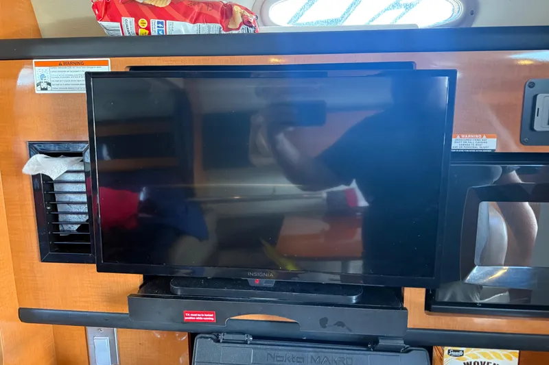 Slide: The Image of Interior of 2009 Chaparral Signature 280 with TV and snacks on shelf. - 31