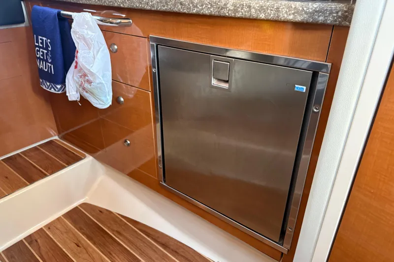 Slide: The Image of 2009 Chaparral Signature 280 interior with stainless steel fridge and wooden cabinetry. - 33