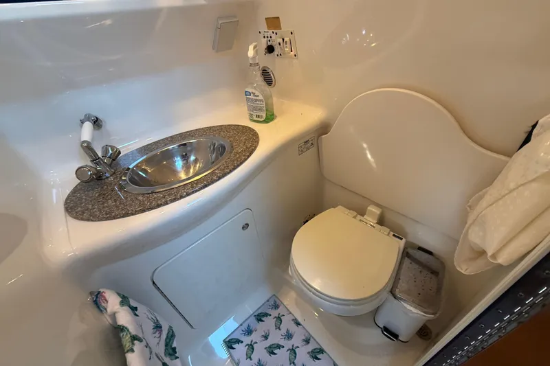 Slide: The Image of 2009 Chaparral Signature 280 boat bathroom with sink, toilet, and cleaning supplies. - 34