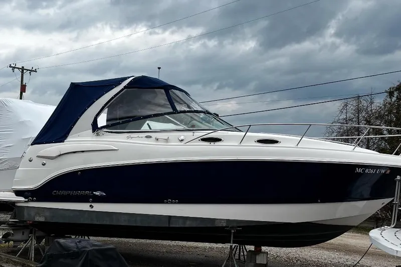 Slide: The Image of 2009 Chaparral Signature 280 boat with blue canopy, parked on a trailer under cloudy skies. - 43