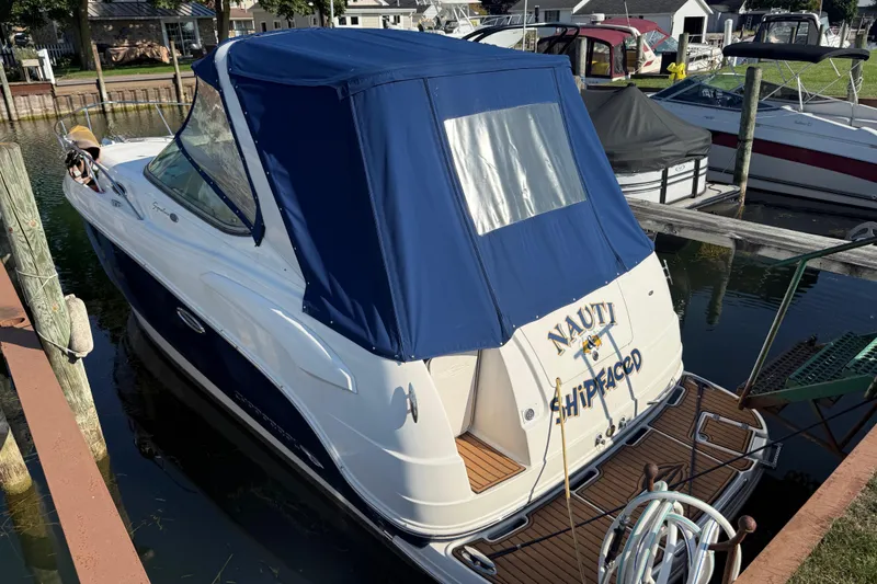 Slide: The Image of 2009 Chaparral Signature 280 boat docked with blue canopy and humorous name. - 7