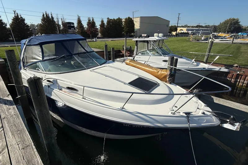 Slide: The Image of 2009 Chaparral Signature 280 boat docked, featuring a sleek design and blue canopy. - 8