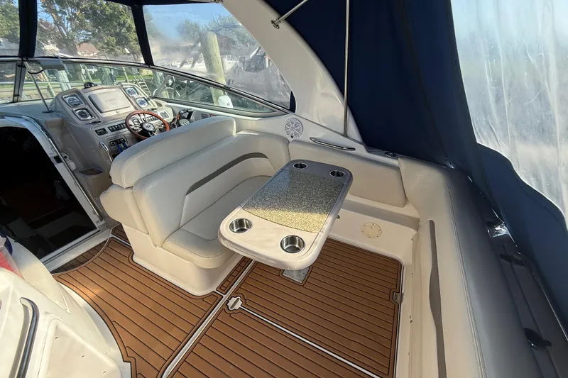 Slide: The Image of 2009 Chaparral Signature 280 interior with helm, seating, and table on teak flooring. - 9
