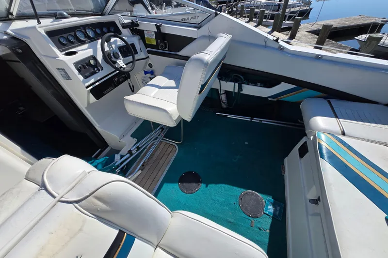 Slide: The Image of Interior of a 1992 Wellcraft Eclipse 233 boat with white seating and teal carpet. - 10