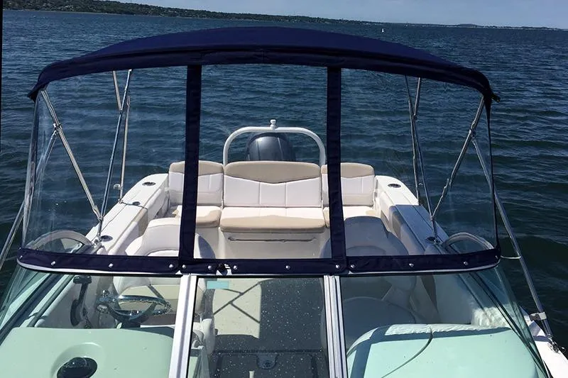 Slide: The Image of 2019 Robalo R207 Dual Console boat on calm water with canopy and seating. - 13