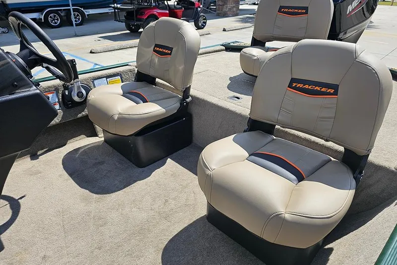 Slide: The Image of 2026 Tracker Bass Tracker Classic Limited boat seats, beige with orange accents, in a sunny setting. - 7