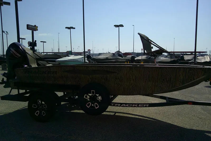 Slide: The Image of 2026 Tracker Grizzly 1650 T Prairie Wings Edition boat on trailer in parking lot. - 10