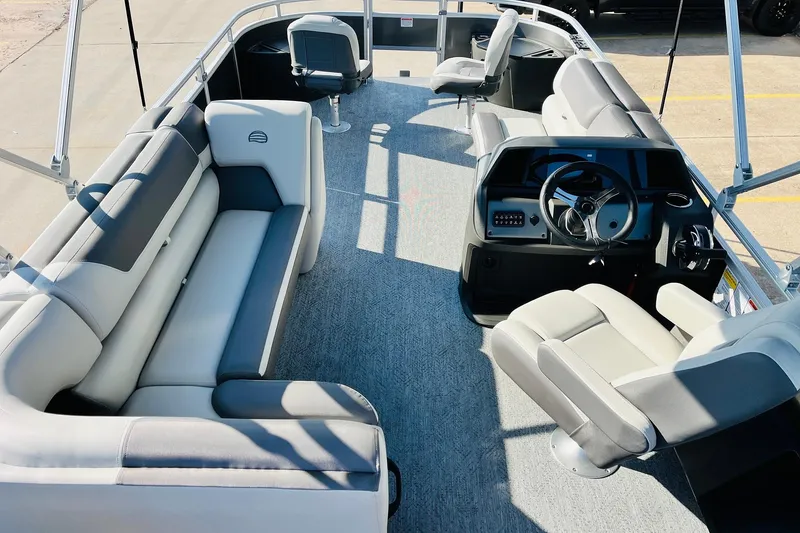 Slide: The Image of 2026 Sun Tracker Fishin' Barge 22 DLX interior with seating and steering console. - 10