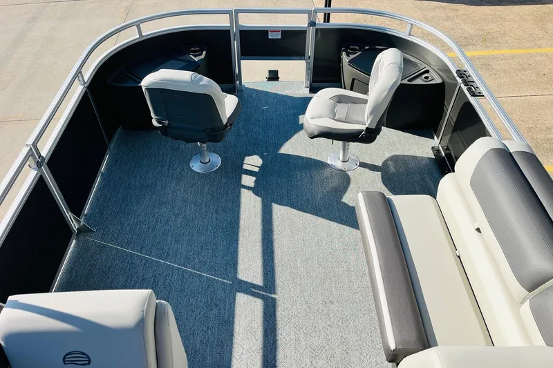 Slide: The Image of 2026 Sun Tracker Fishin' Barge 22 DLX interior with seating and carpeted deck. - 11