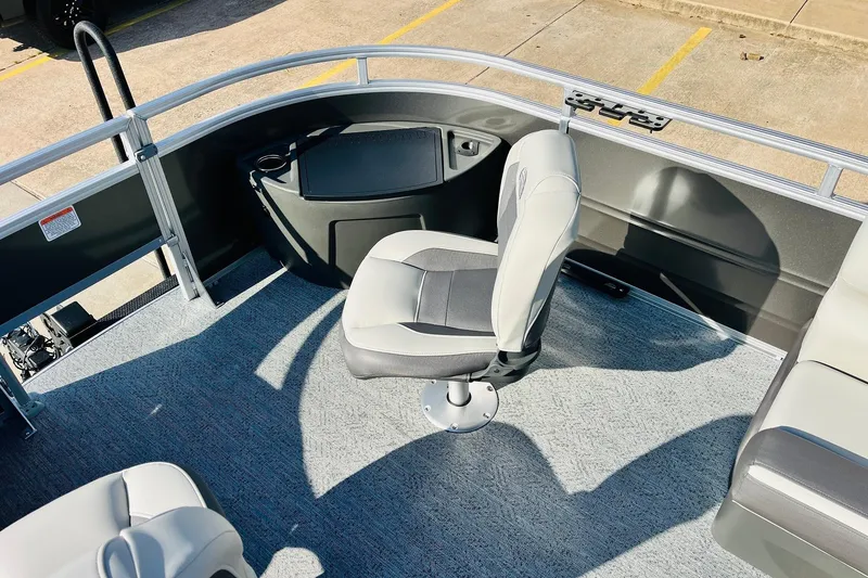 Slide: The Image of 2026 Sun Tracker Fishin' Barge 22 DLX interior with swivel chair and carpeted deck. - 14