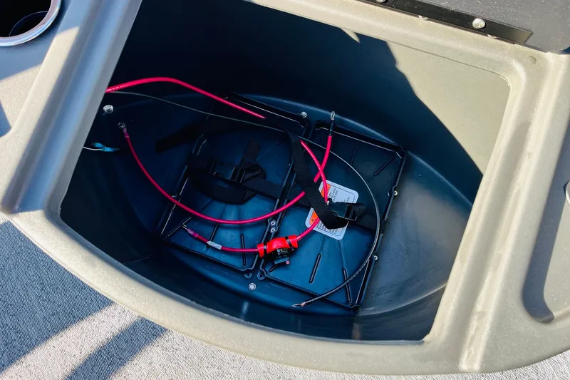 Slide: The Image of Battery compartment of 2026 Sun Tracker Fishin' Barge 22 DLX with wiring and straps. - 15