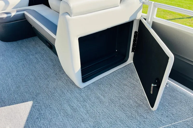 Slide: The Image of Open storage compartment on 2026 Sun Tracker Fishin' Barge 22 DLX boat. - 23