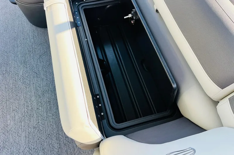 Slide: The Image of 2026 Sun Tracker Fishin' Barge 22 DLX storage compartment with cushioned seating. - 26