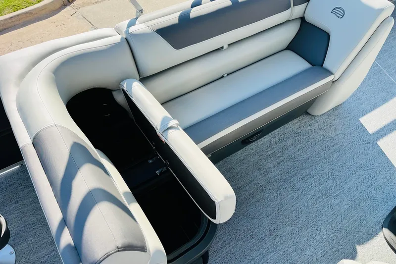 Slide: The Image of 2026 Sun Tracker Fishin' Barge 22 DLX boat seating with storage compartment open. - 29