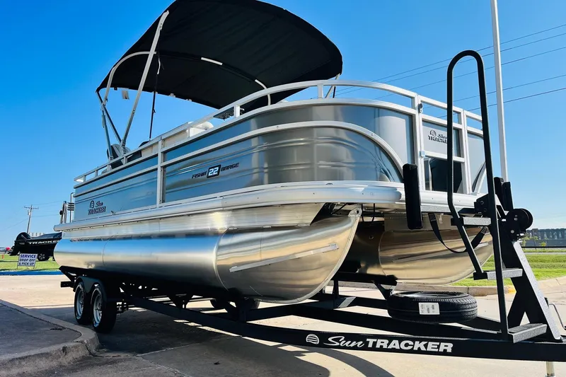 Slide: The Image of 2026 Sun Tracker Fishin' Barge 22 DLX pontoon boat on trailer, sunny day. - 3