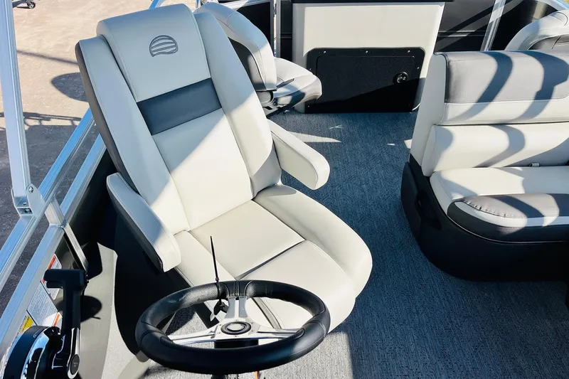 Slide: The Image of 2026 Sun Tracker Fishin' Barge 22 DLX interior with steering wheel and comfortable seating. - 36