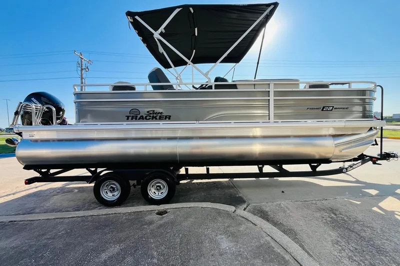 Slide: The Image of 2026 Sun Tracker Fishin' Barge 22 DLX pontoon boat on trailer, side view. - 4