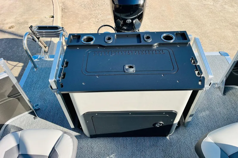 Slide: The Image of 2026 Sun Tracker Fishin' Barge 22 DLX boat console with cup holders and storage. - 48