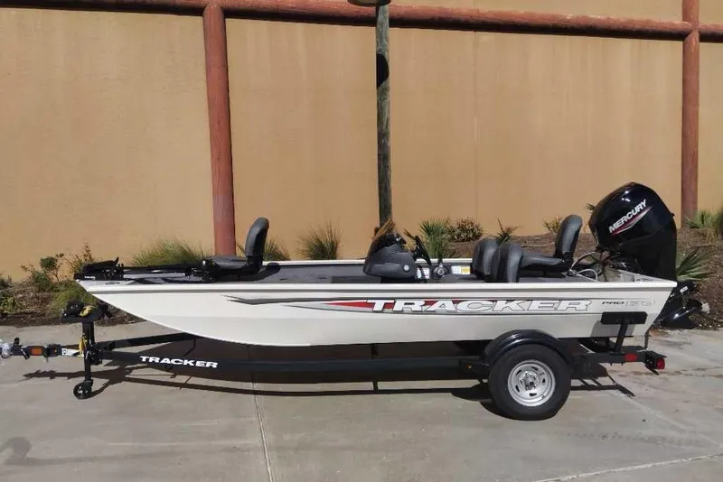 The Image of 2026 Tracker Pro 170 boat on trailer, parked outdoors, featuring Mercury outboard motor. - 0