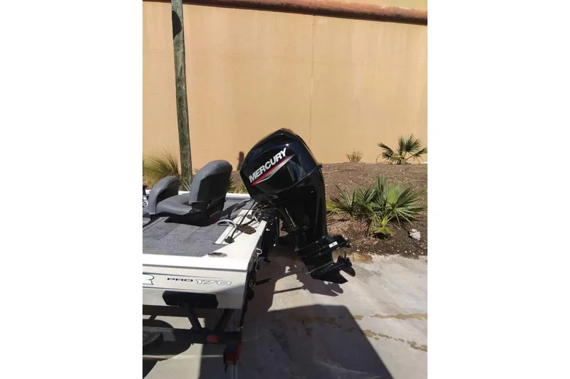 Slide: The Image of 2026 Tracker Pro 170 boat with Mercury outboard motor, parked outdoors. - 3