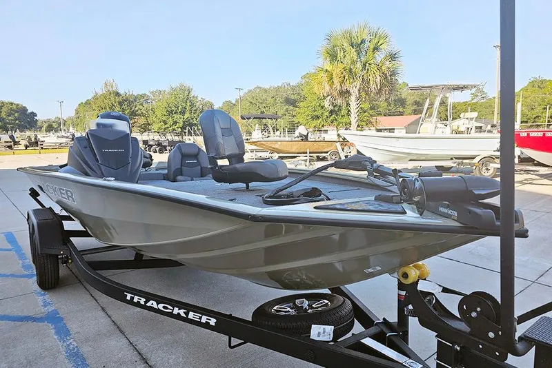 Slide: The Image of 2026 Tracker Pro Team 195 boat on trailer, parked outdoors with other boats nearby. - 6