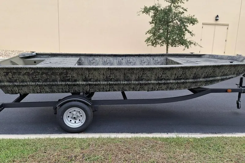 Slide: The Image of 2026 Tracker Grizzly 1648 Utility boat on trailer, parked outdoors. - 2