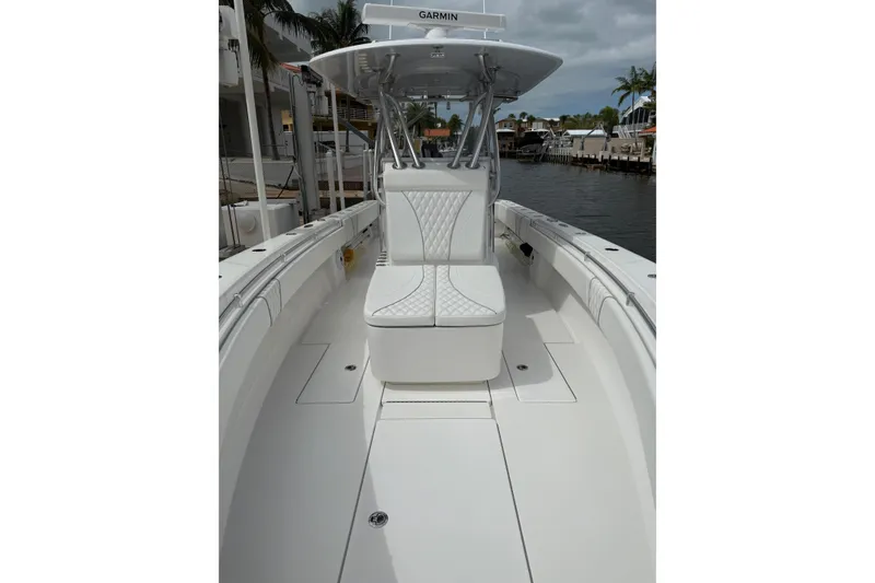 Slide: The Image of 2024 Contender 32 ST boat with white seating, docked by a canal. - 11