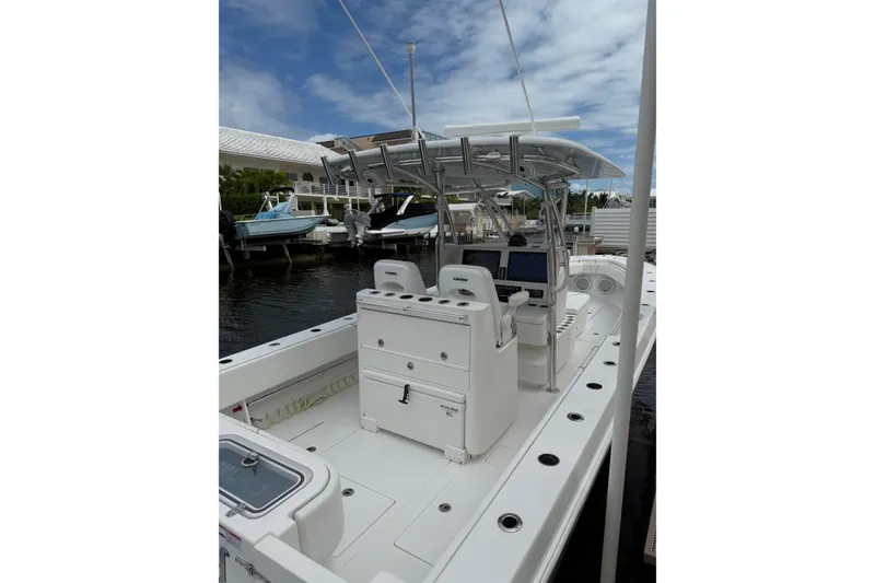 Slide: The Image of 2024 Contender 32 ST boat with dual consoles and T-top, docked under a cloudy sky. - 15