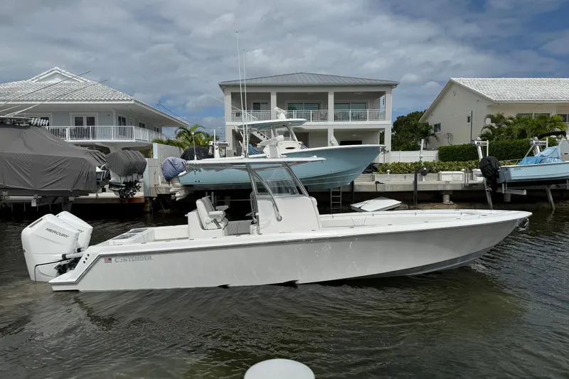 Slide: The Image of 2024 Contender 32 ST boat docked near waterfront homes under cloudy skies. - 17