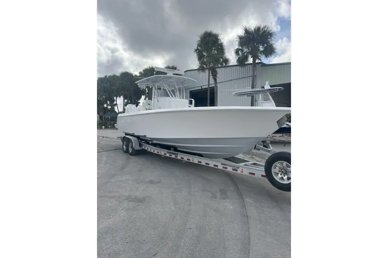 Slide: The Image of 2024 Contender 32 ST boat on trailer, parked outdoors near palm trees. - 3