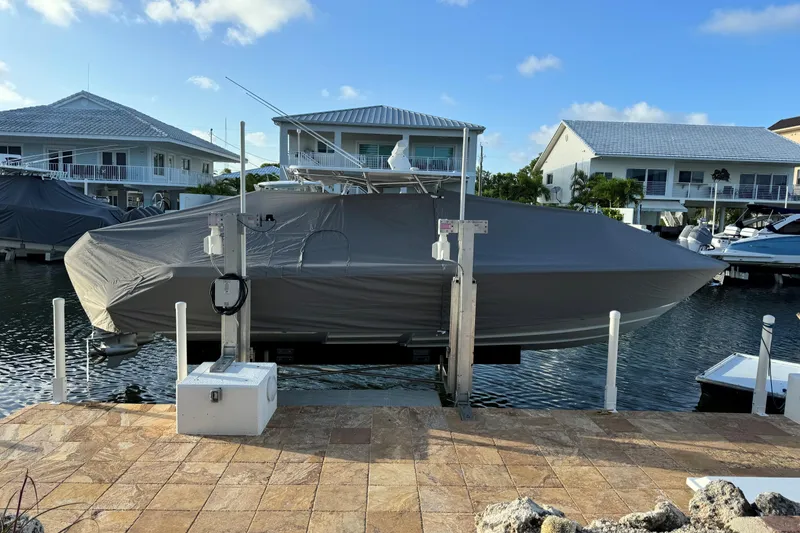 Slide: The Image of 2024 Contender 32 ST boat covered and docked in a marina setting. - 6