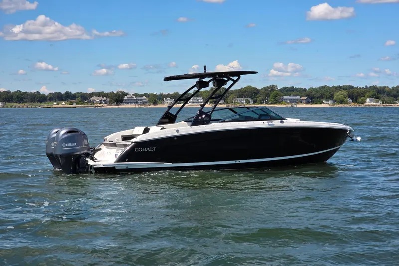 Slide: The Image of 2024 Cobalt R8 Outboard boat on water, clear sky, shoreline in background. - 1